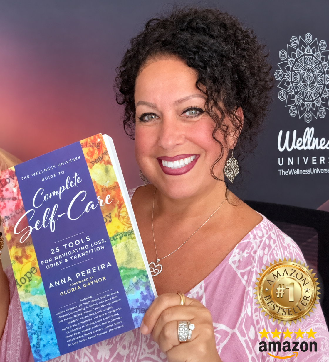 Anna Pereira holding her bestselling book, 25 Tools for Navigating Loss, Grief & Transition