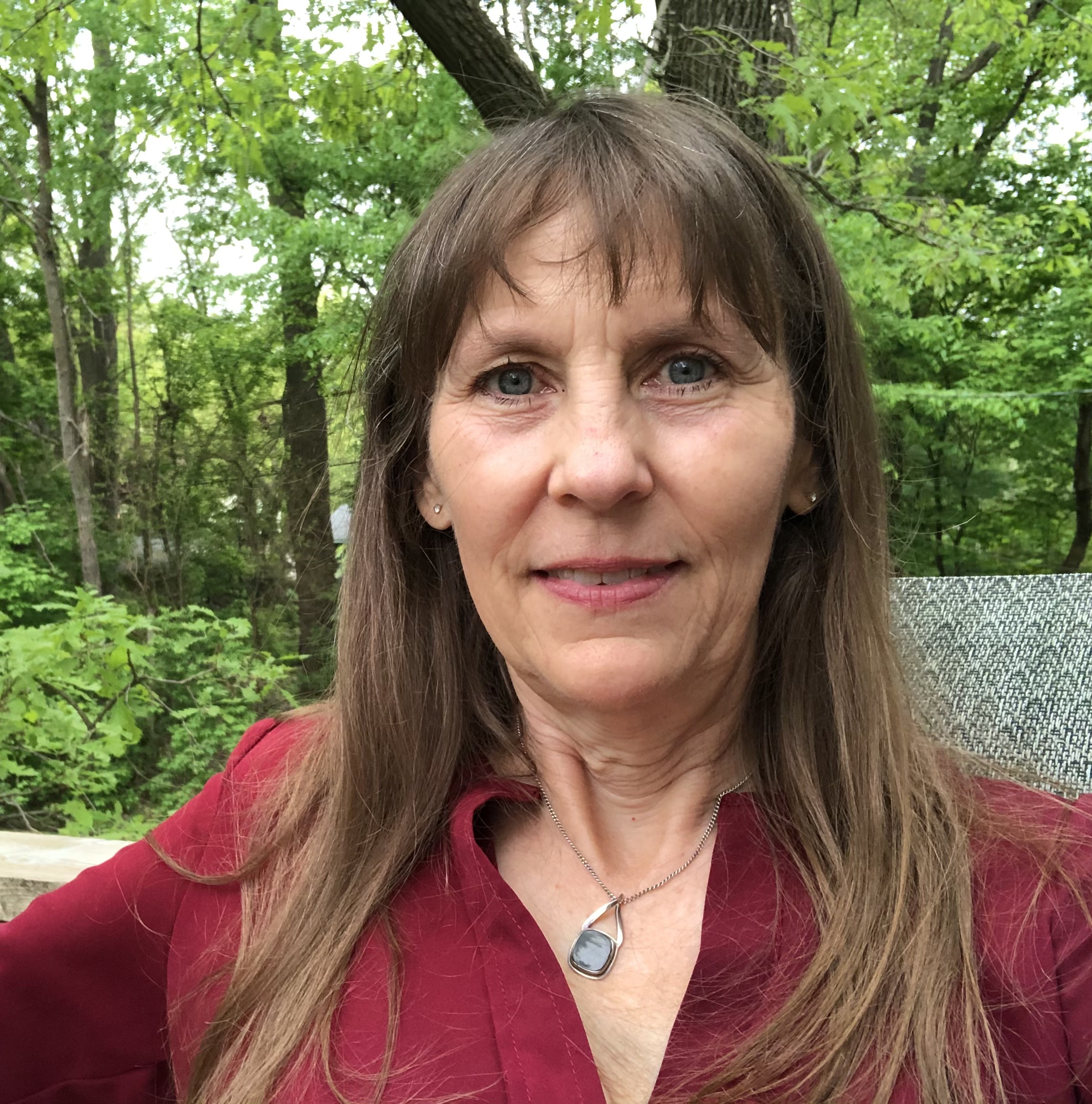Leah Skurdal outdoors among green trees