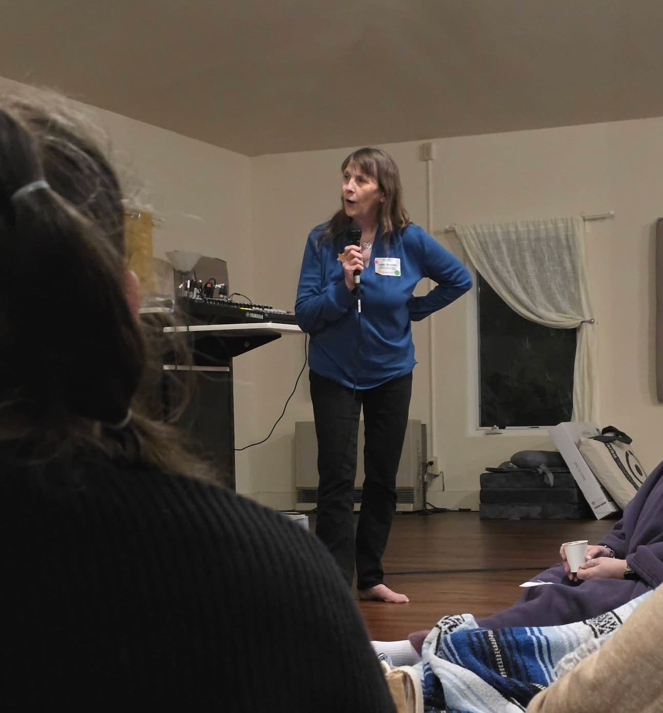 Leah Skurdal speaking barefoot to a retreat group at SoulTreat